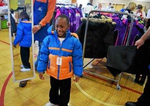 Kemoni Johnson, six, trying on his new winter coat during Operation School Bell at Alcott Elementary School on Thursday, Oct. 13, 2016.